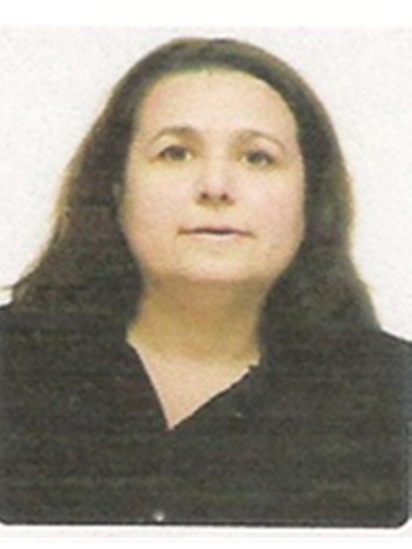 Mulher de pele clara, cabelos escuros na altura dos ombros.