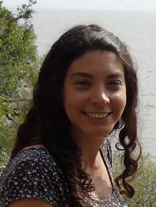 Mulher de pele morena clara, de olhos e cabelos longos crespos escuros.