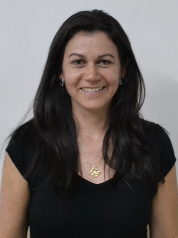 Mulher sorridente de pele clara, cabelos castanhos, lisos e compridos.