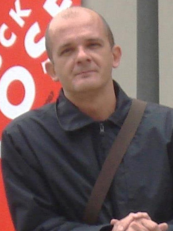 Homem de pele clara e calvo.