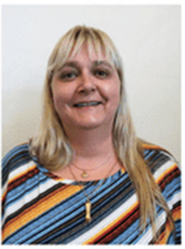 Mulher sorridente de pele clara, cabelos louros, lisos e compridos, com franja.