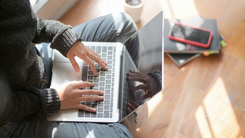 Mo&ccedil;a acessando a internet por meio de um Notebook