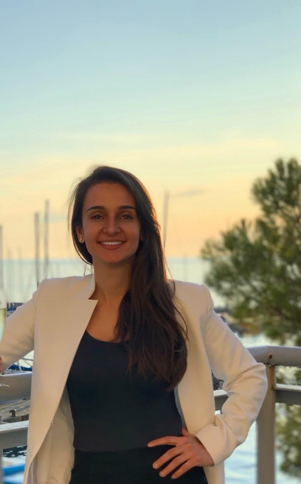 Foto colorida da Bárbara. Mulher jovem, de cabelos longos escuros, pele morena clara.