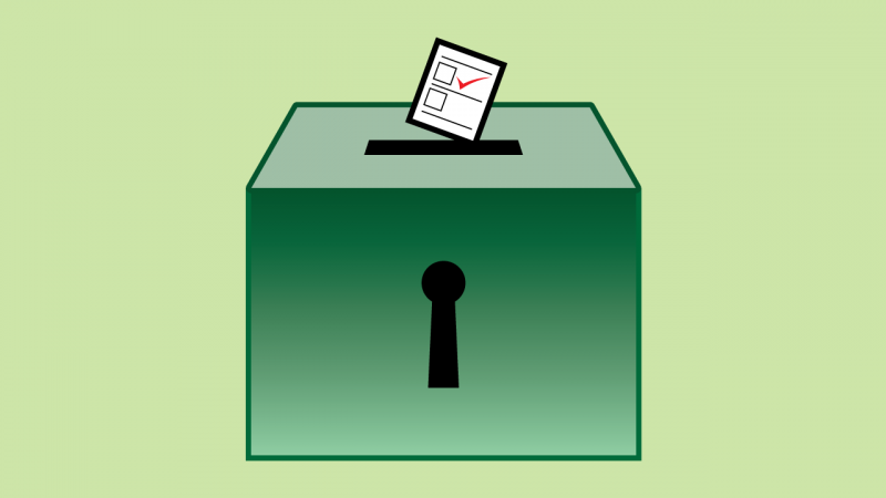 Imagem colorida com fundo verde claro. Ao centro, uma caixa verde escura com uma abertura no topo, com uma c&eacute;dula de papel sendo colocada nela. Na c&eacute;dula, v&ecirc;-se dois quadrados, com uma marca&ccedil;&atilde;o em V na cor vermelha em um deles.