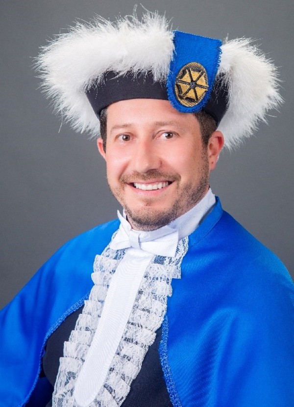 Homem de pele clara, olhos e cabelos curtos escuros.